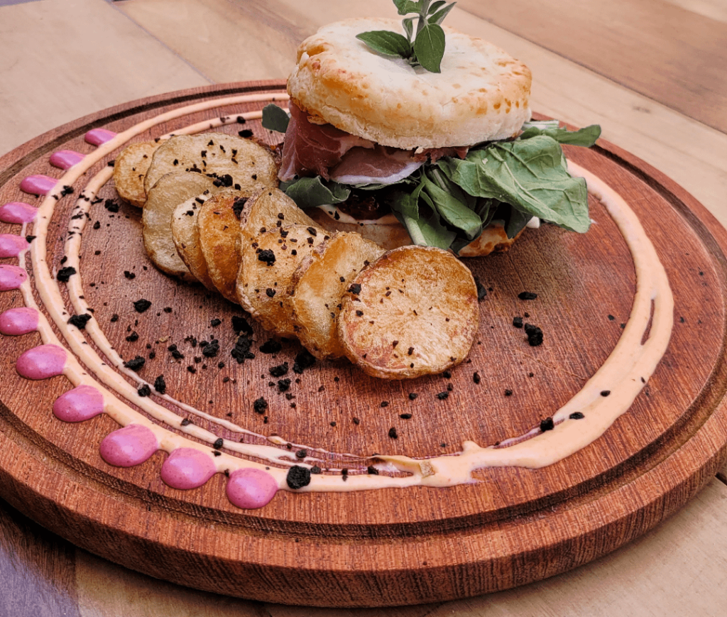 The best sandwich made with cheese bread, arugula, dried tomatoes and cream cheese accompanied by potatoes and beet sauce