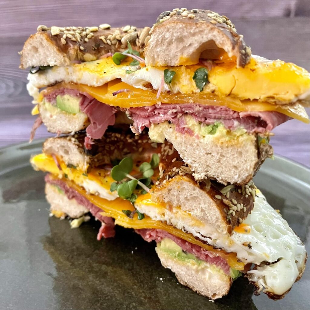 Avocado, pastrami, cheddar and fried eggs with sriracha mayo and cress on everything bagel