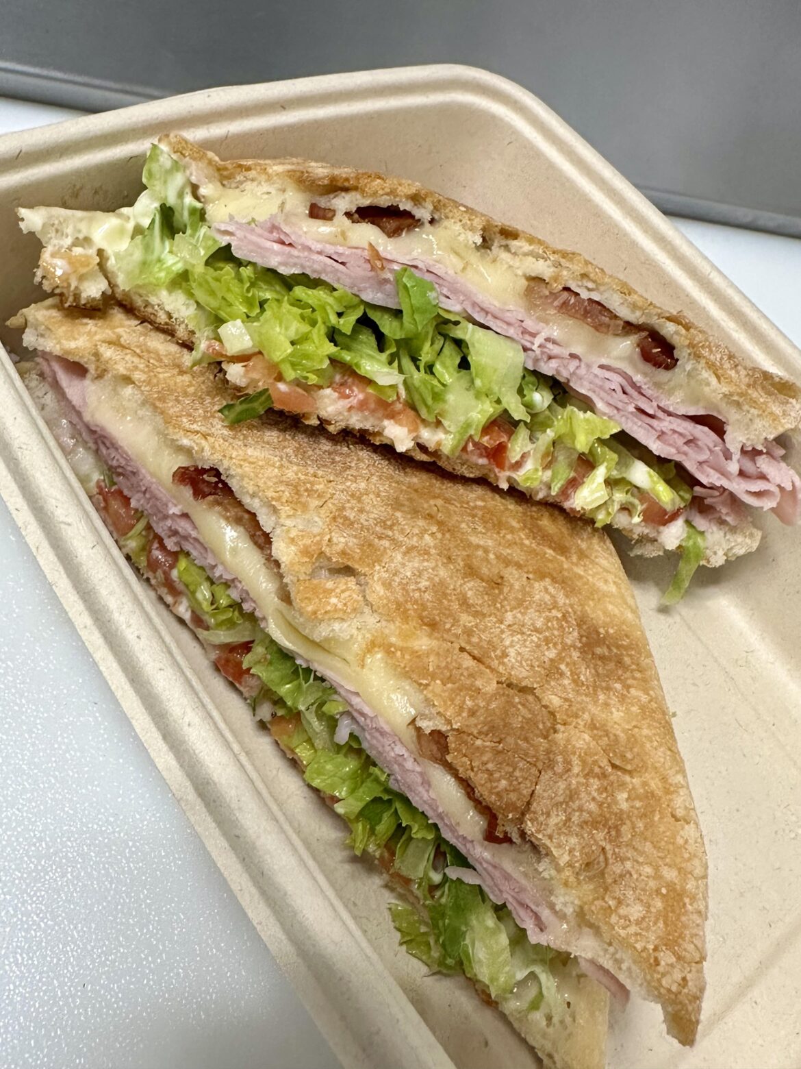 Ham and Swiss with lettuce, tomatoes, bacon, salt, pepper, oil and vinegar.