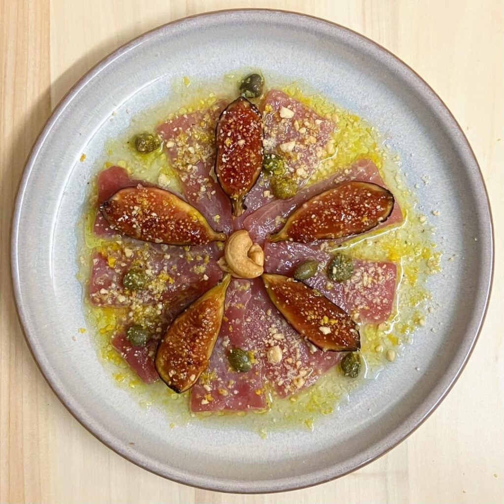Tuna Carpaccio with 24hr Soy-Marinated Figs, caramelised and topped with a Citrus Caper Vinaigrette and Cashew Crumb