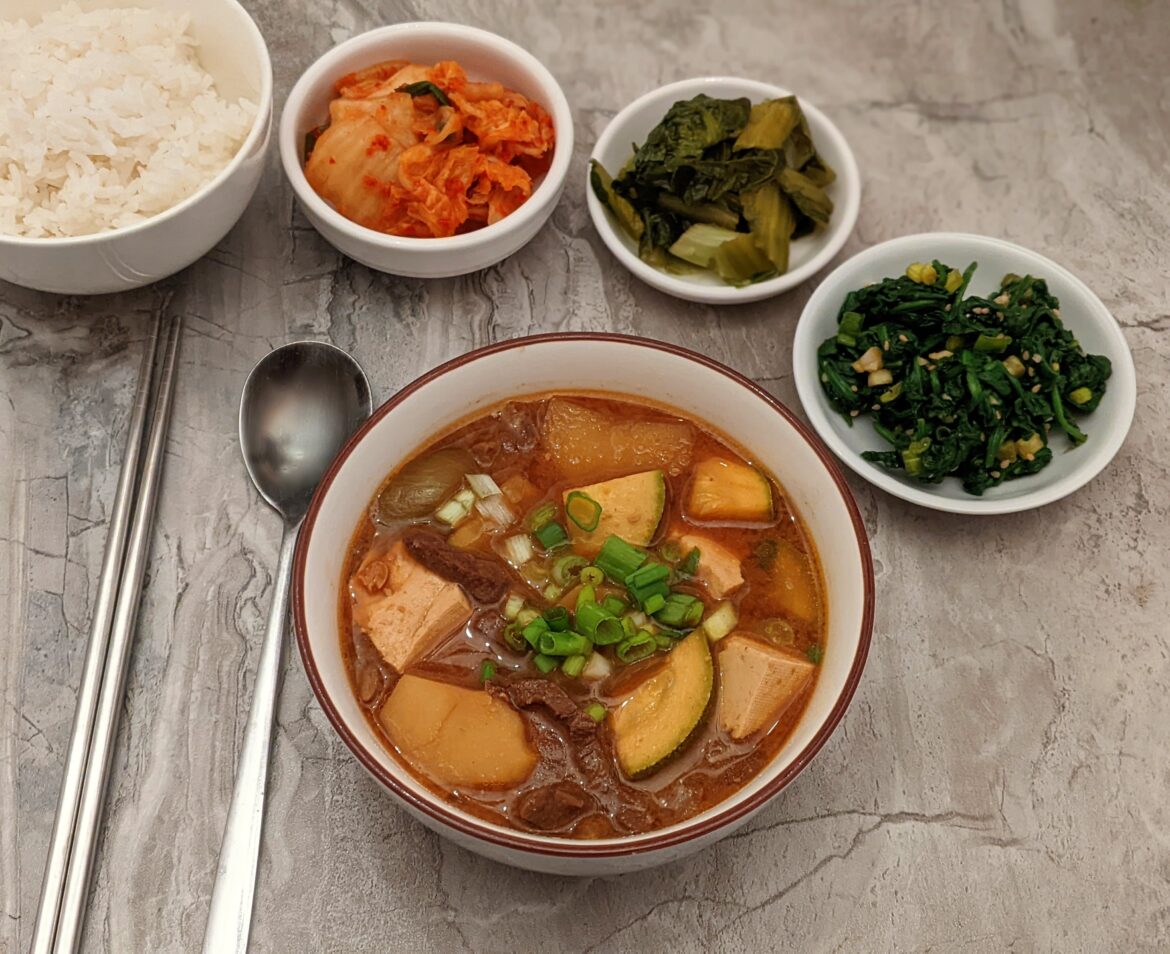 Sogogi doenjang jjigae, kimchi, fermented mustard greens, sigeumchi namul.
