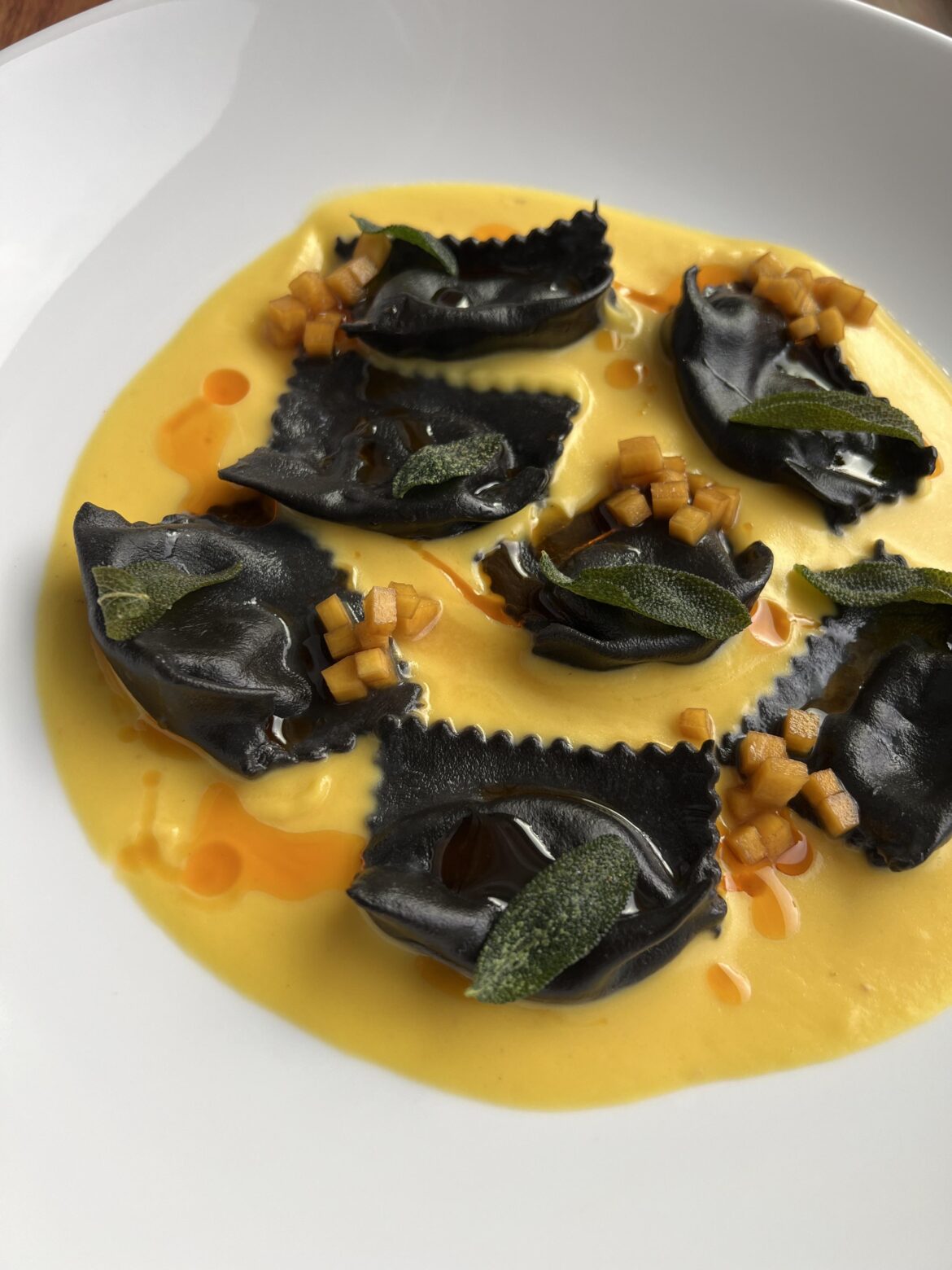 Squid Ink Agnolotti | Pumpkin Cream Sauce | Pickled Pumpkin | Fried Sage I Calabrian Chili Oil
