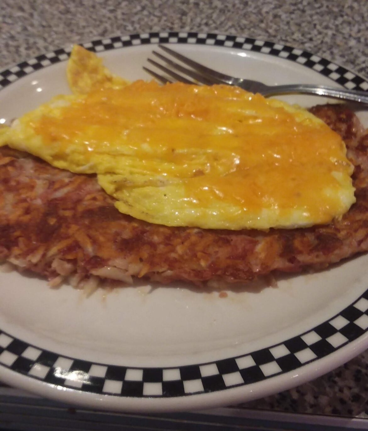 Cheddar and scrambled egg over corned beef hash.