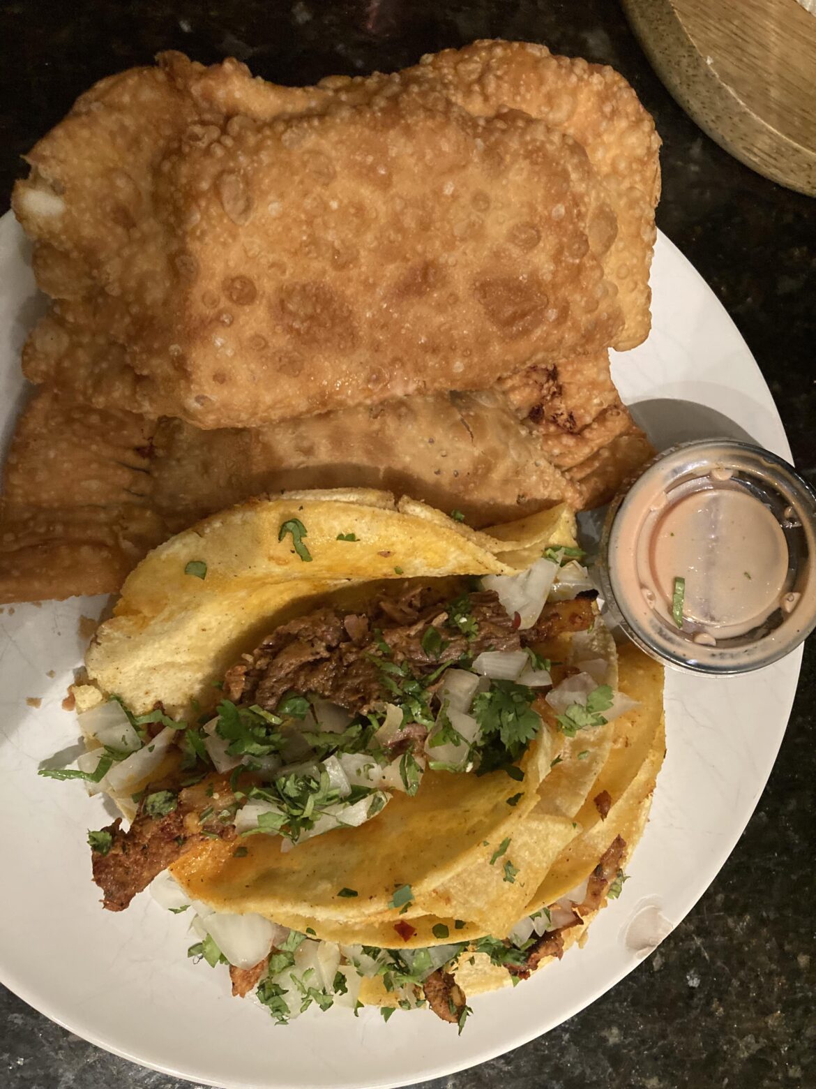 Carnitas & al pastor tacos with barbacoa empanadas and rasada.