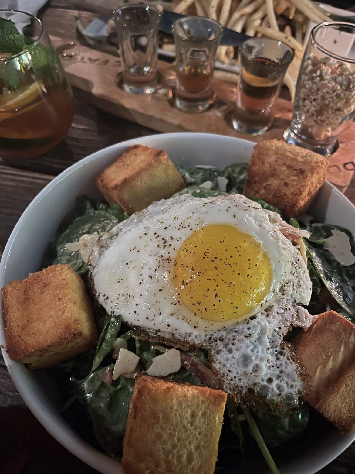 spinach caesar salad with bacon, brioche croutons & a fried egg