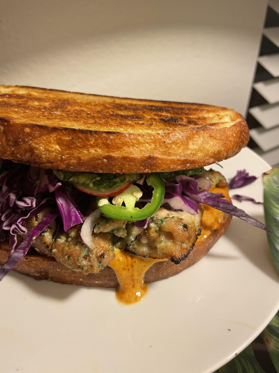 Gai yang chicken sandwich with curry mayo, slaw, and Thai-style chimichurri on sourdough