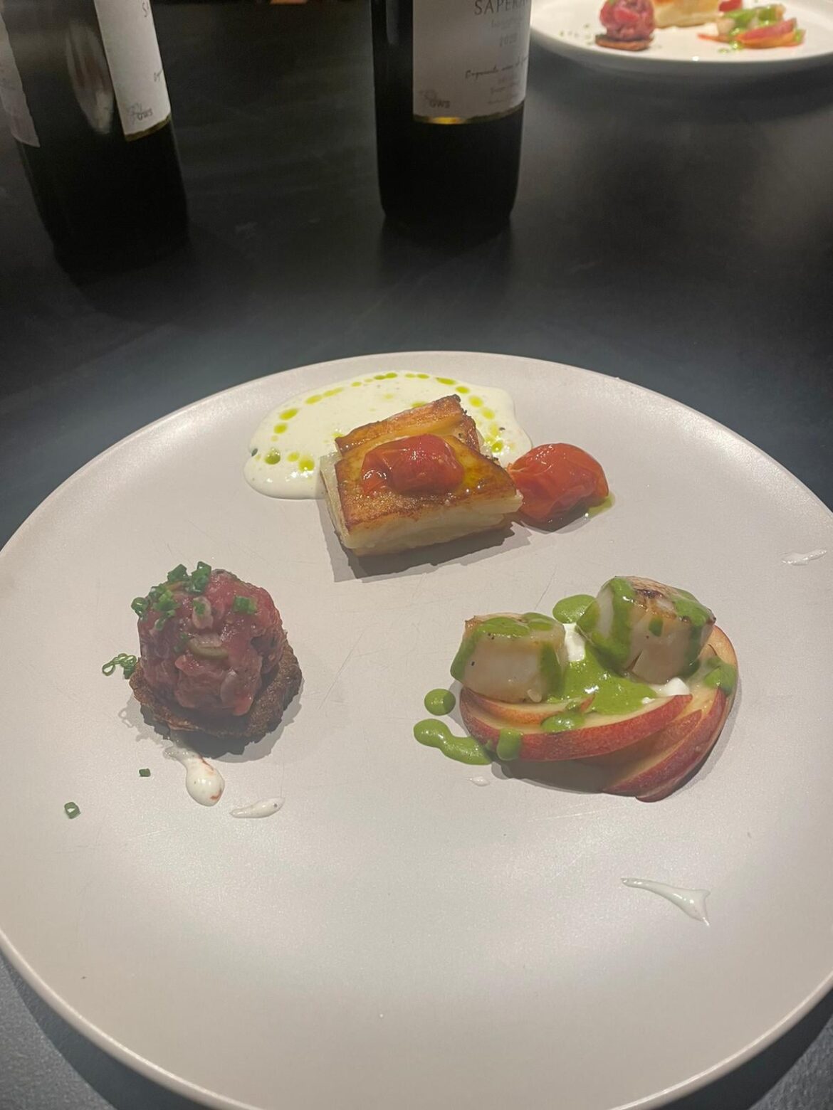 Three mouthfuls starter: dry aged steak tartare with a Yorkshire pudding disk, scallop with peaches and cream, potatoe terrine with confit tomatoes and manchego cream