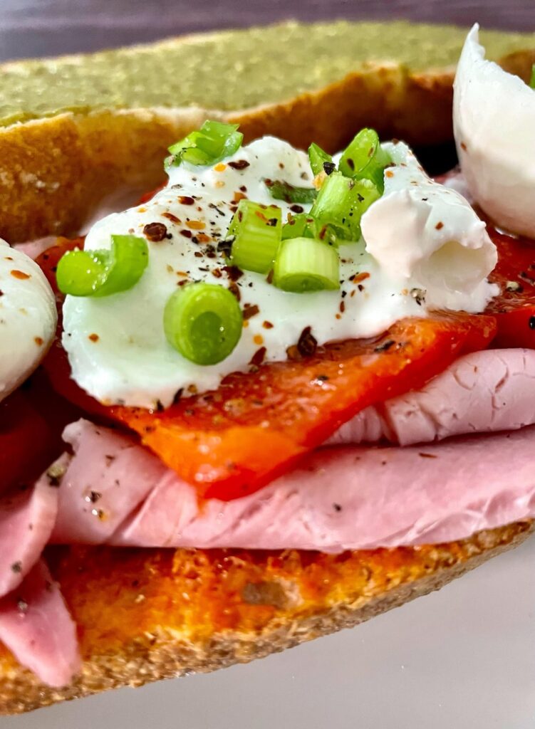 Buffalo burrata with marinated grilled belt peppers and Prosciutto cotto on baguette with green and red pesto