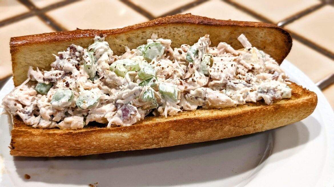 Cashew bacon chicken salad sandwich topped with ghost pepper flakes