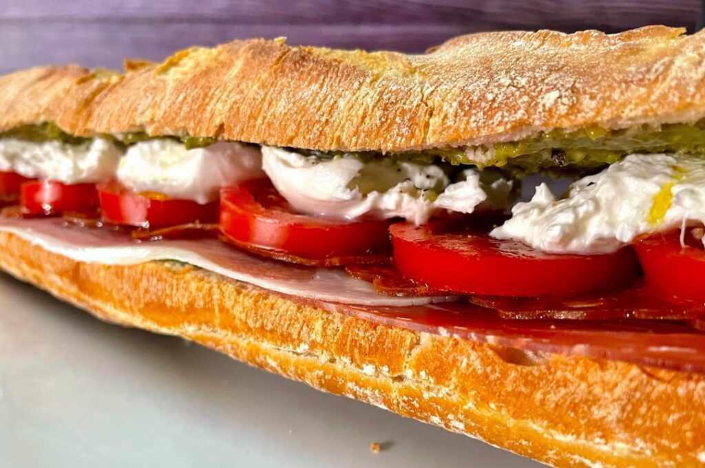 Burrata pesto baguette with serrano, chorizo, tomato and baby spinach