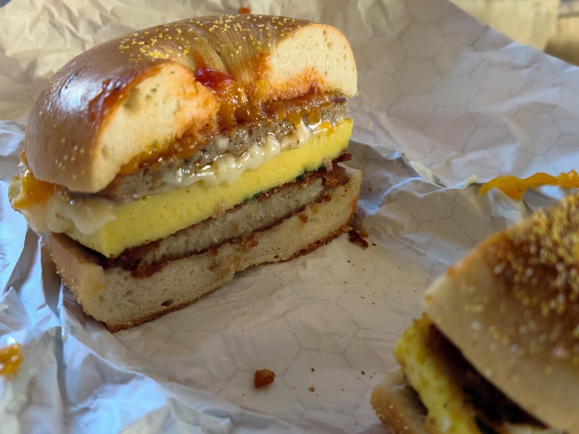 Breakfast sausage, herbed omelette, American Cheese, aged cheddar, ketchup, hash brown latke on an onion bagel