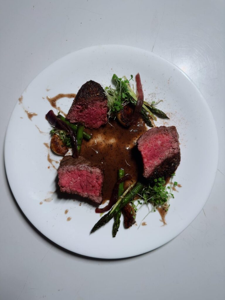 Steak with sautéed asparagus and a red wine reduction