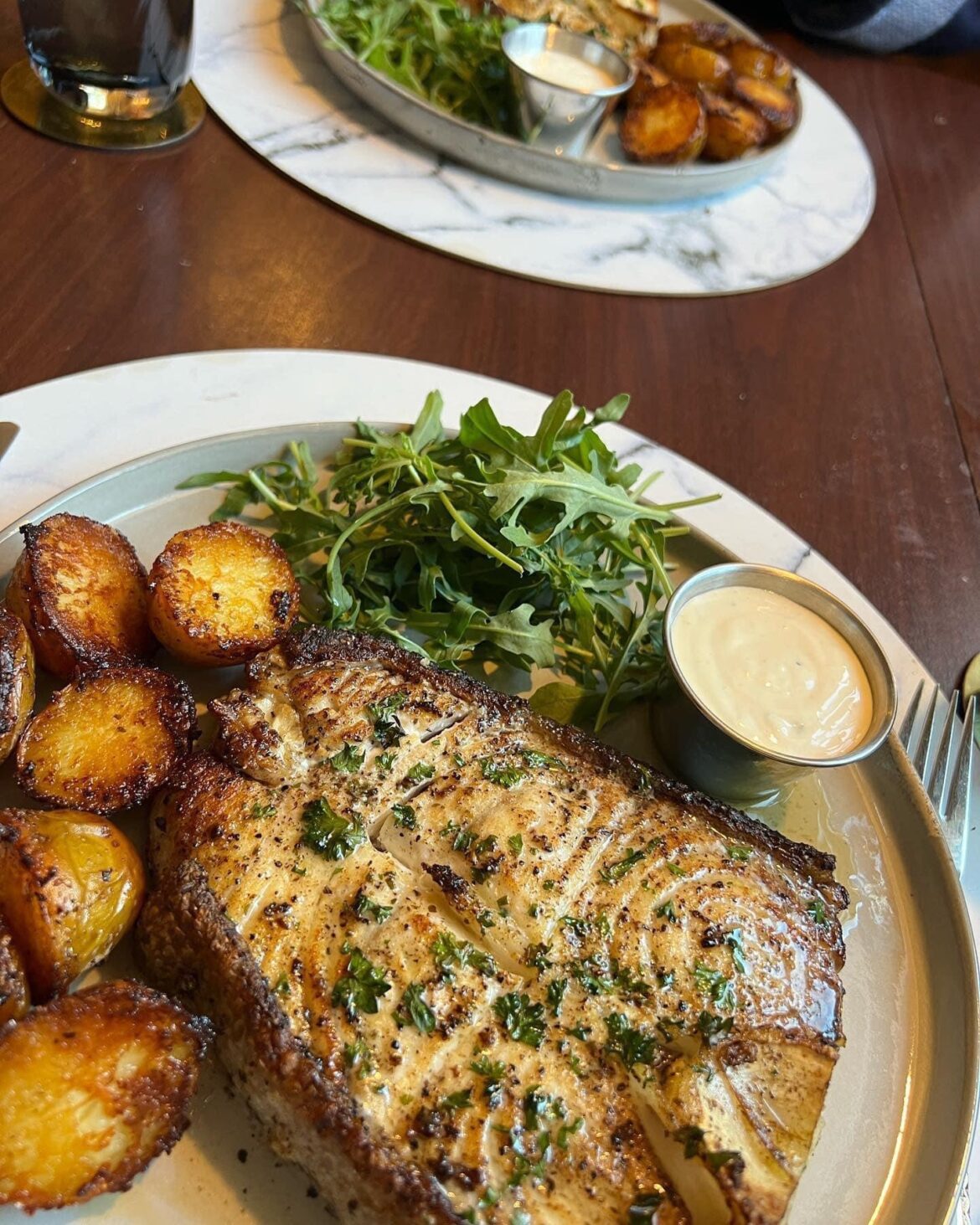 Panfried halibut with arugula, garlic sauce and parmesan-butter baked potatoes.