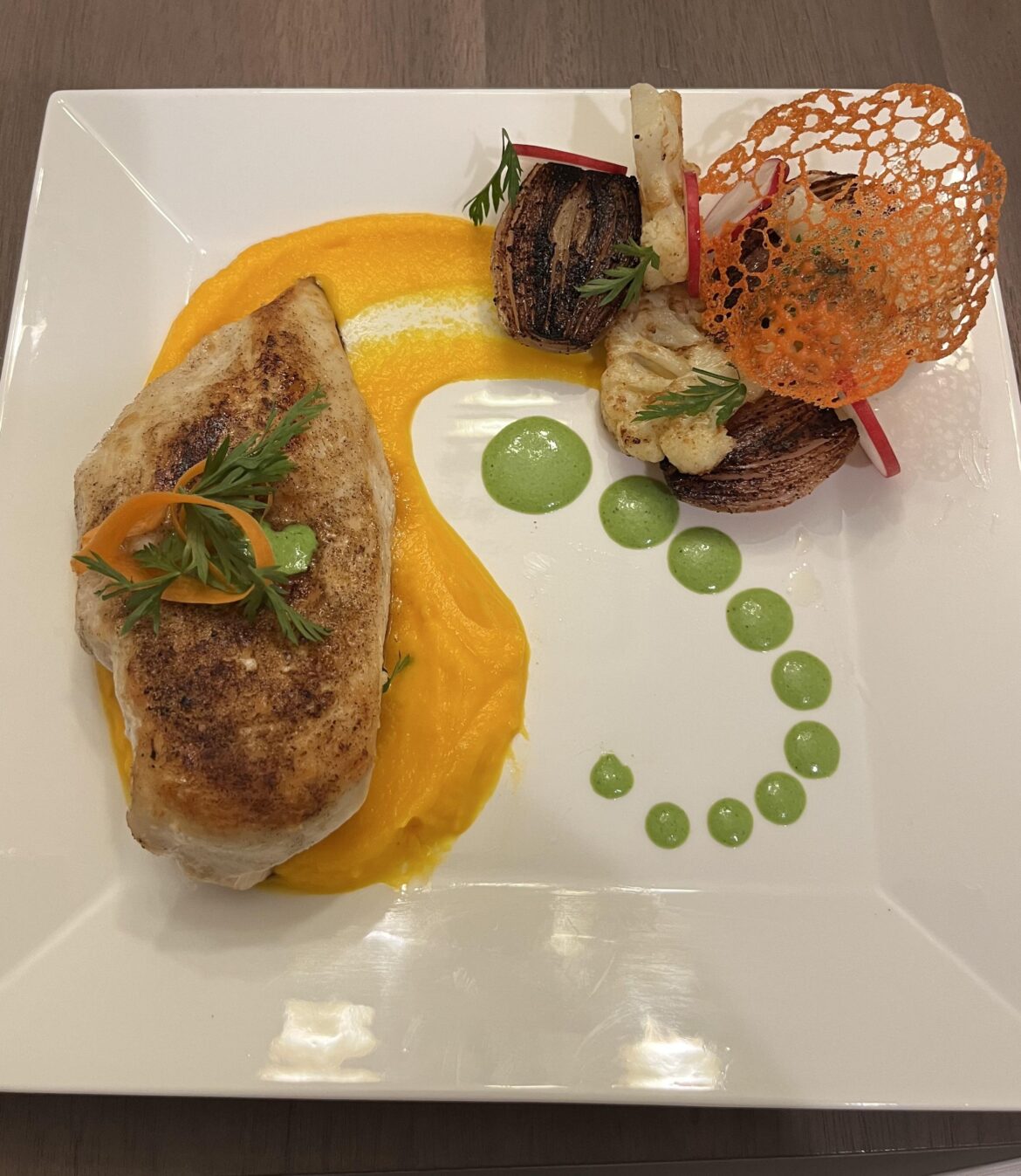 Chicken breast with carrot puree, aji verde, and garlic butter cauliflower and shallots