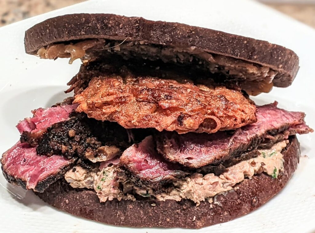 3 Momentous Meals in One Sandwich! <swipe> •The smoked turkey gravy jam my brother made on Thanksgiving •The smoked chopped liver and pastrami he made for my birthday last week •A Hanukkah latke leftover I made last night reheated in my air fryer •All on toasted pumpernickel