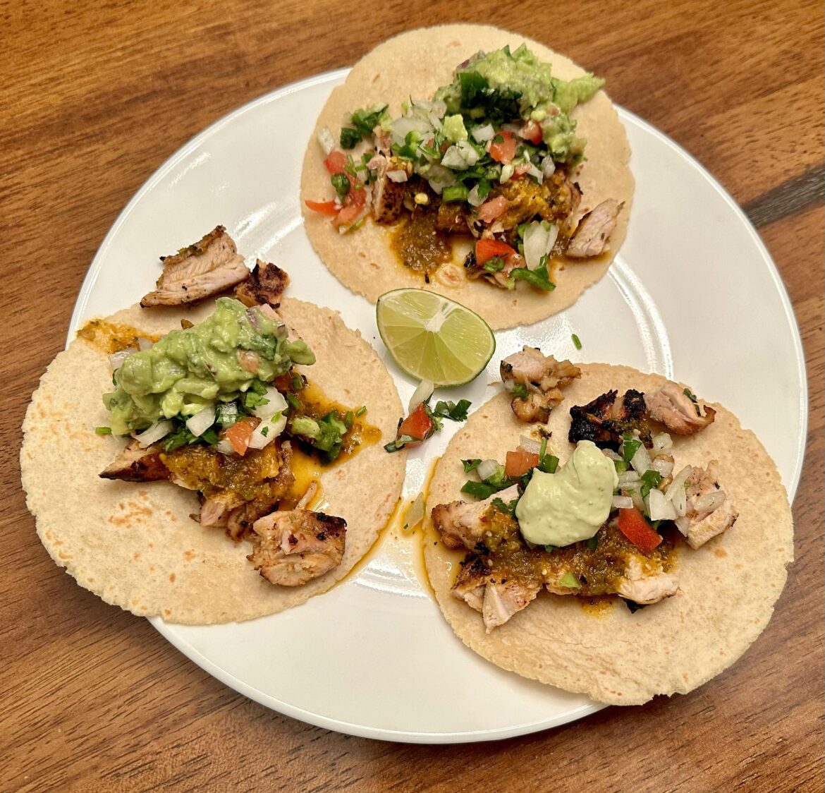 Pollo Asado tacos with roasted habanero and tomatillo salsa, guacamole, avocado crema, and pico de gallo
