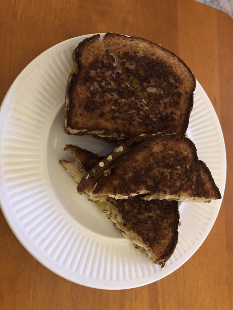 My wife made me two grilled munster cheese and rotisserie chicken with jalapeño on oat bread