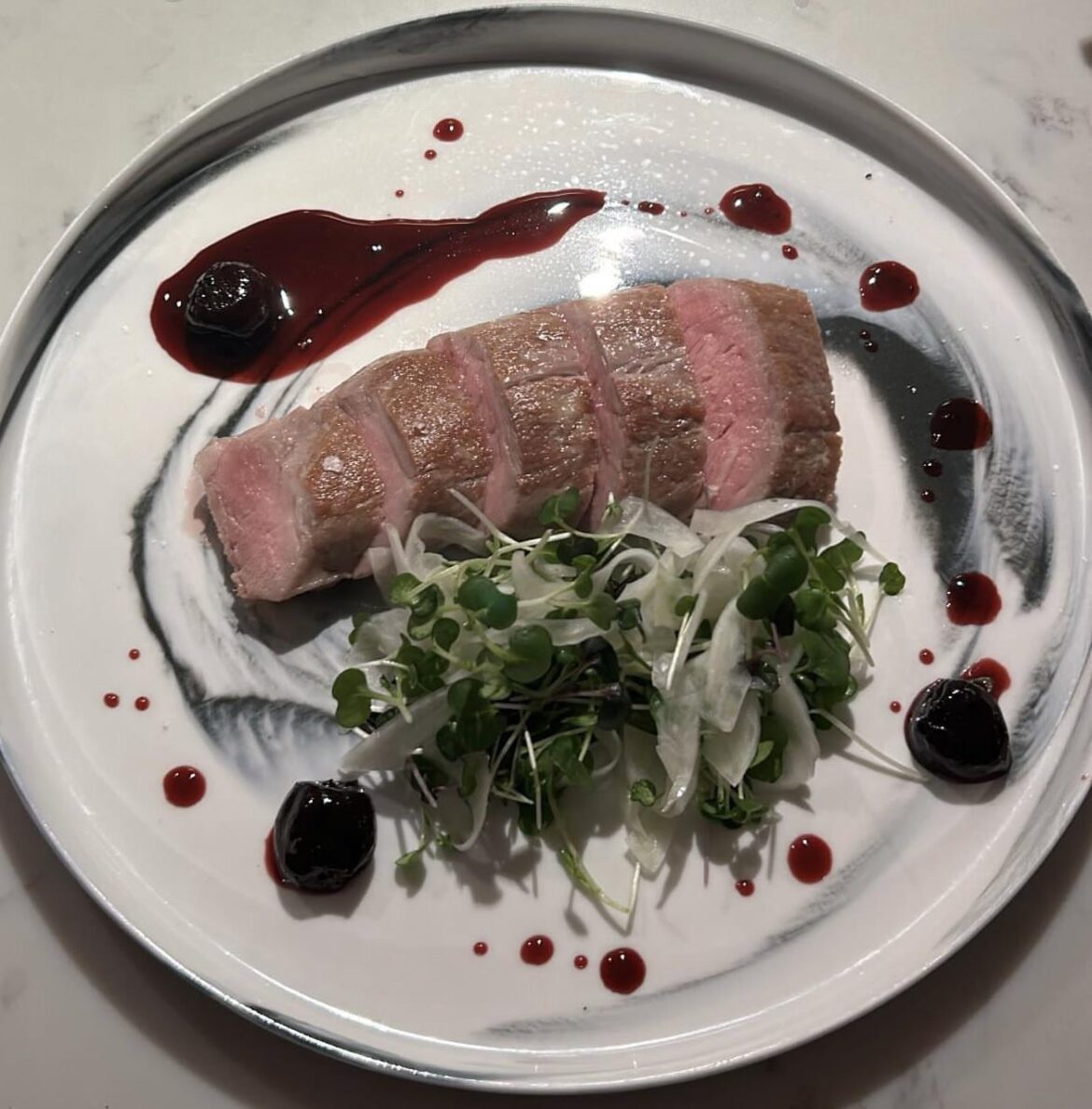 Sous vide pork tenderloin, fennel and micro green salad, dark cherry gastrique