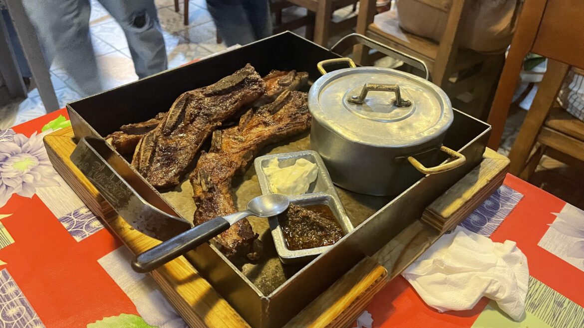 Hearty Asado Argentino on a Towering Planchetta - Spoon Included for a True Sense of Grandeur!