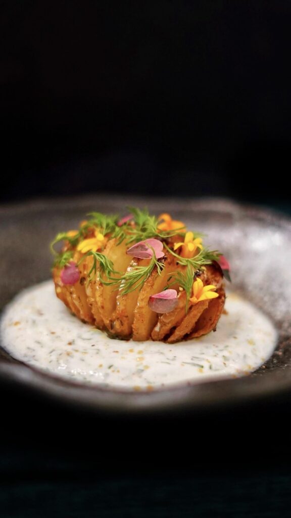 Aloo Suva Hasselback Potato with dill and chaat masala yogurt sauce and pistachio