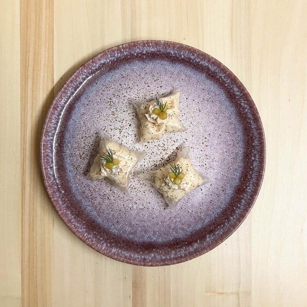 Rice Paper Pillows filled with Smoked Salmon and Dill Mousse, topped with Soy-Marinated Cucumber and dusted with Furikake