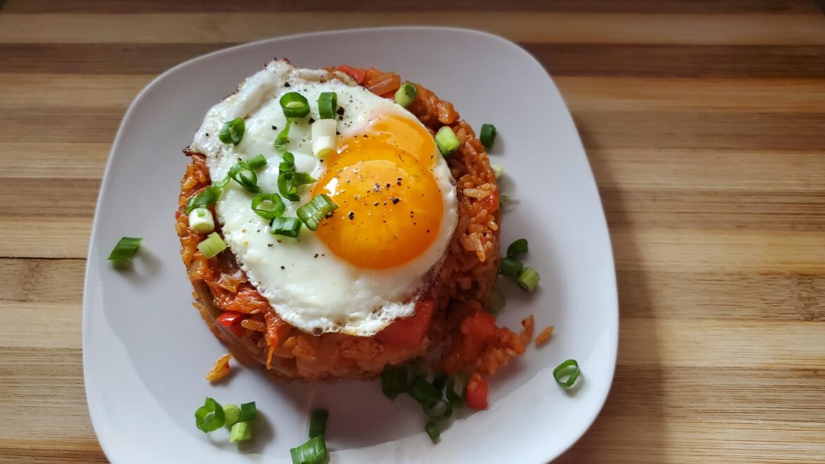 Kimchi fried rice with chopped bell peppers and onions. Topped with fried egg.