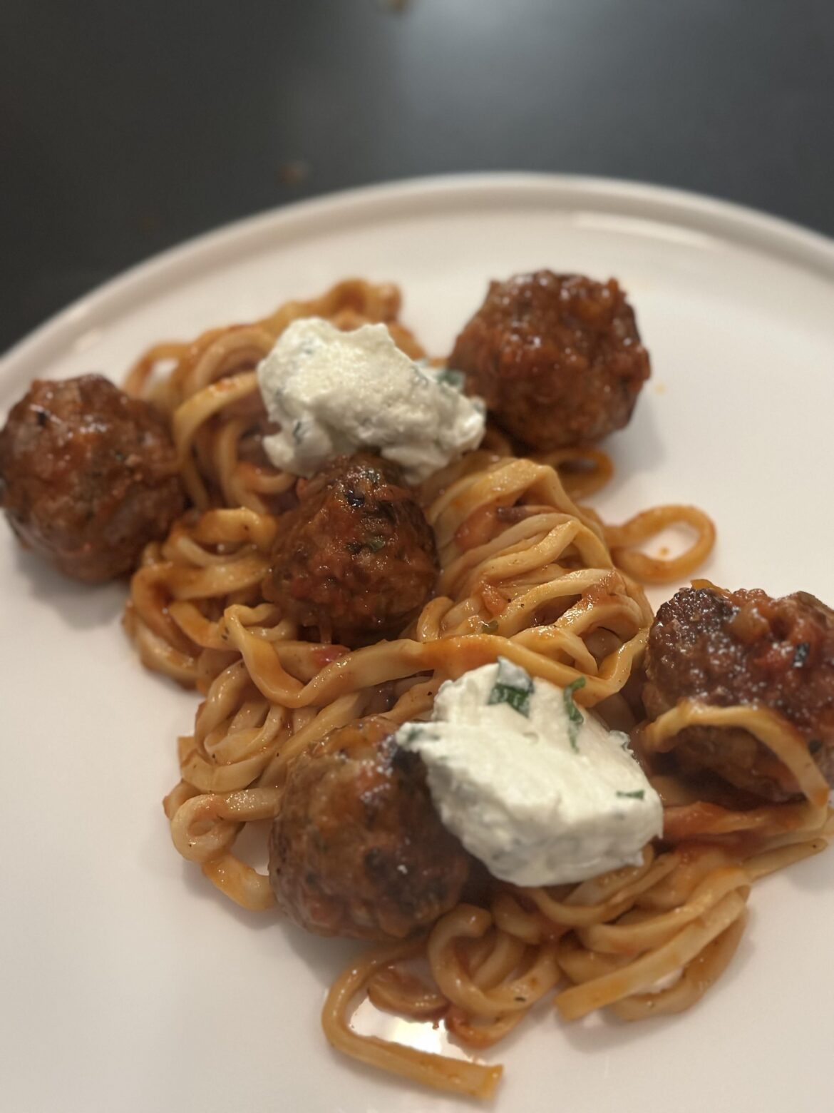 Homemade pasta with spicy meatballs, tomato sauce, and basil ricotta