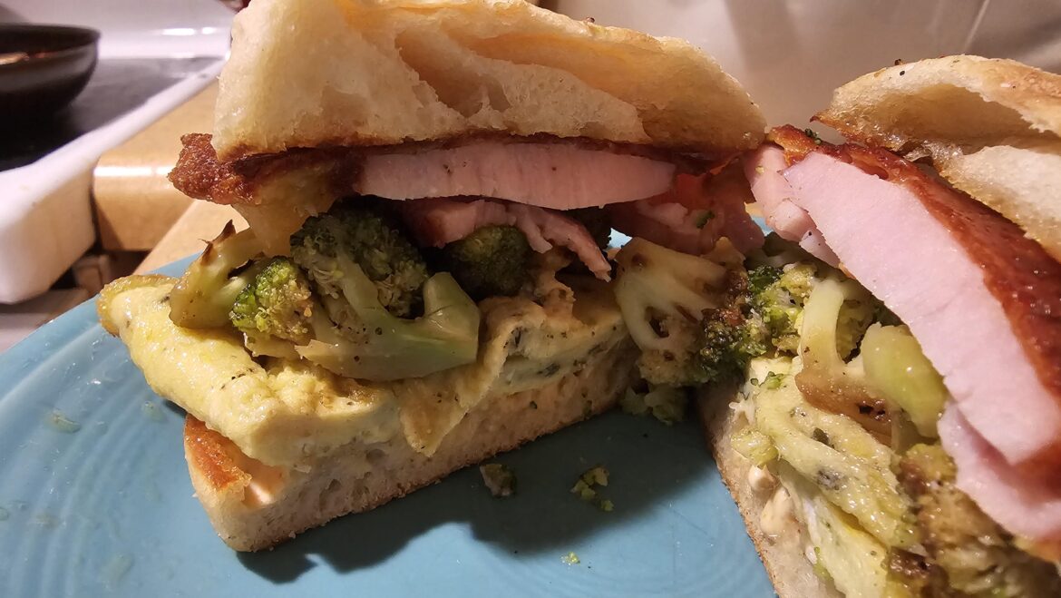 Ham, egg, cheese, broccoli, and hot sauce mayo on English muffin