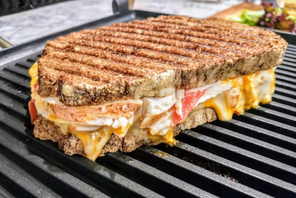 Homemade Turkey Melt/Panini - Roasted Turkey, Pepper Jack Cheese, Tomato, and Horseradish Mayo on Dark Rye Bread.
