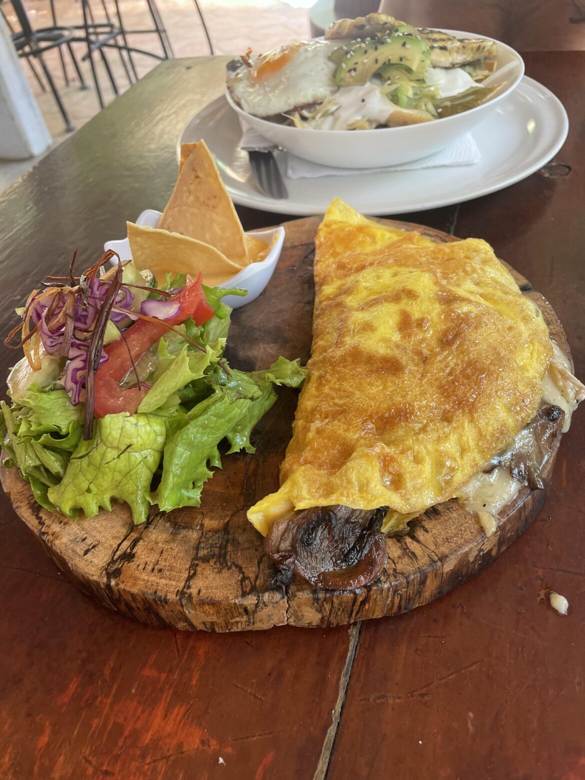 Omelette and salad on a flat board ☹️ the melted cheese and the salad dressing were pretty messy hahaha