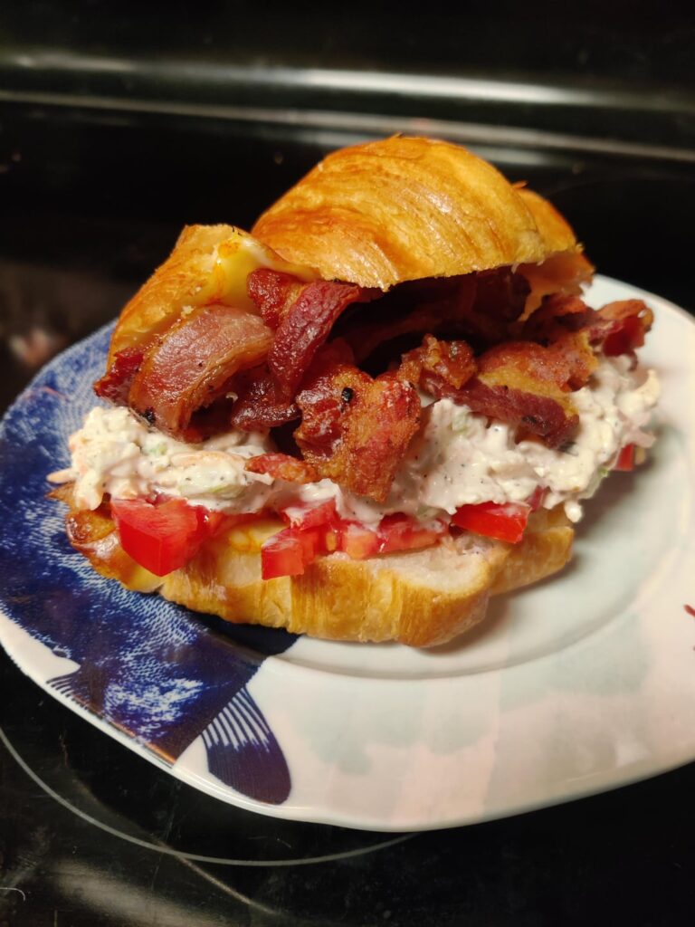 Chicken salad on a toasted croissant w/ melted münster & a bed of sliced Roma tomato