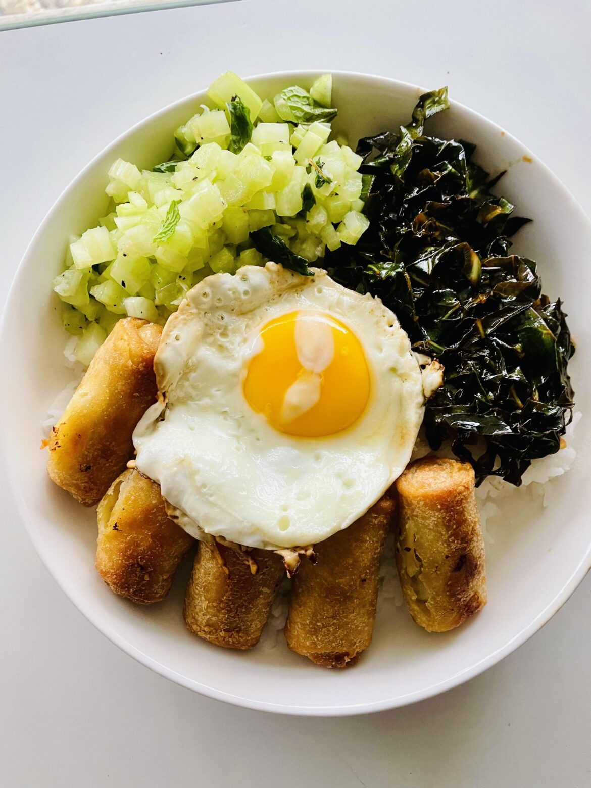 Rice bowl with collard greens, egg rolls and pickled celery salad. Oh, and an egg.