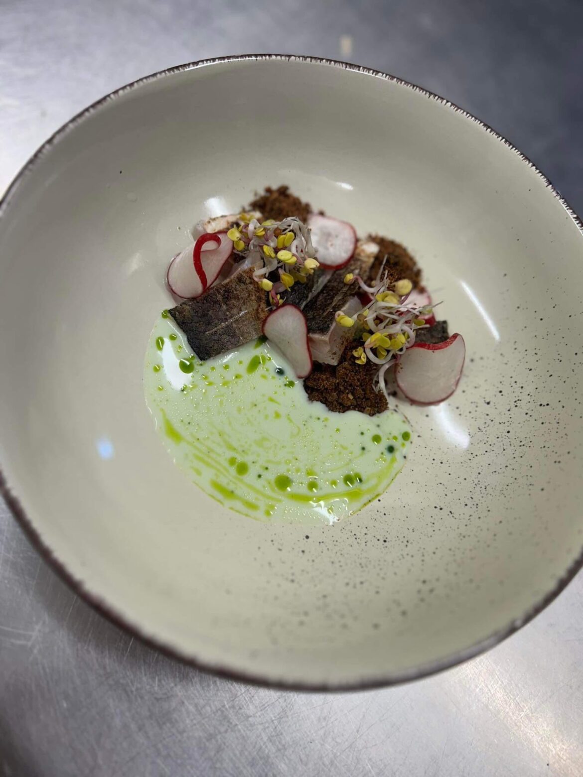 Marinated and blowtorched seabass served with dill-buttermilk sauce, raddish sprout,pickled raddish and rye bread crumb.