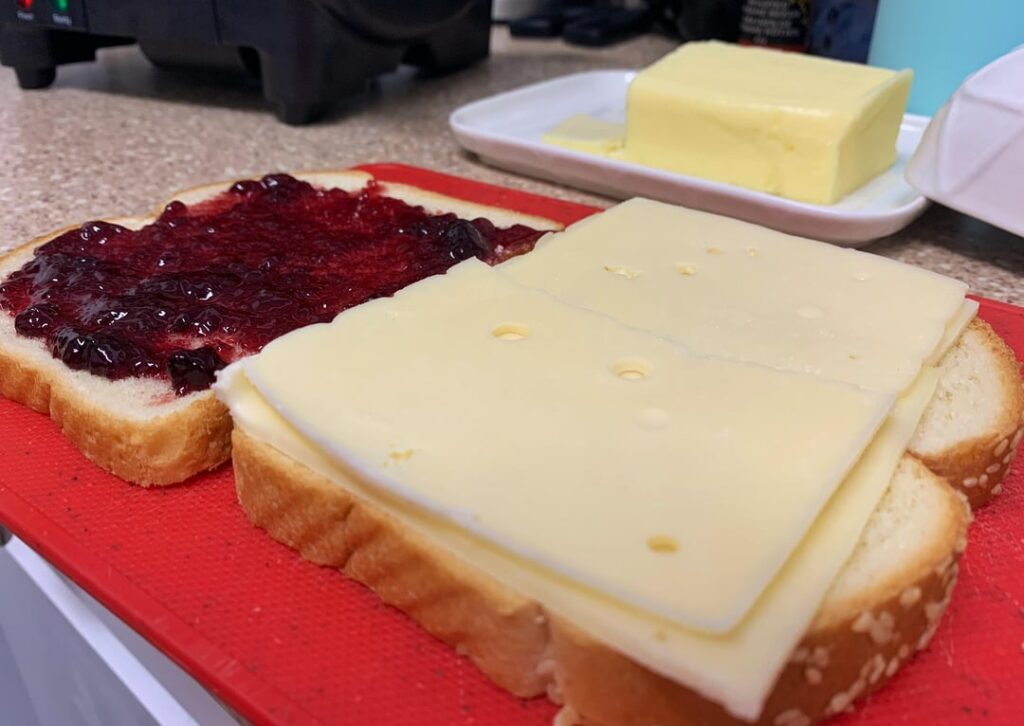 Butter, Swiss cheese, and blackcurrant jelly on sesame white.