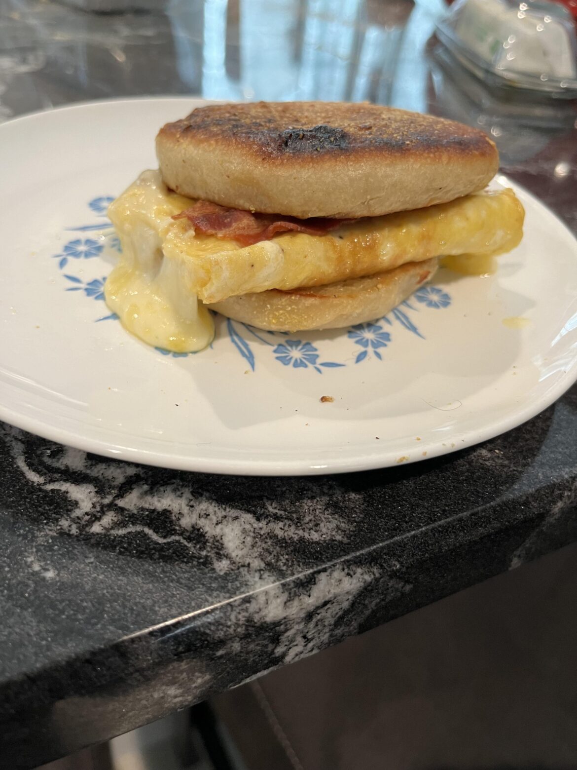 Bacon, egg, and cheese on homemade English muffin. 1/2 of a 3-egg omelette with Cooper sharp American.