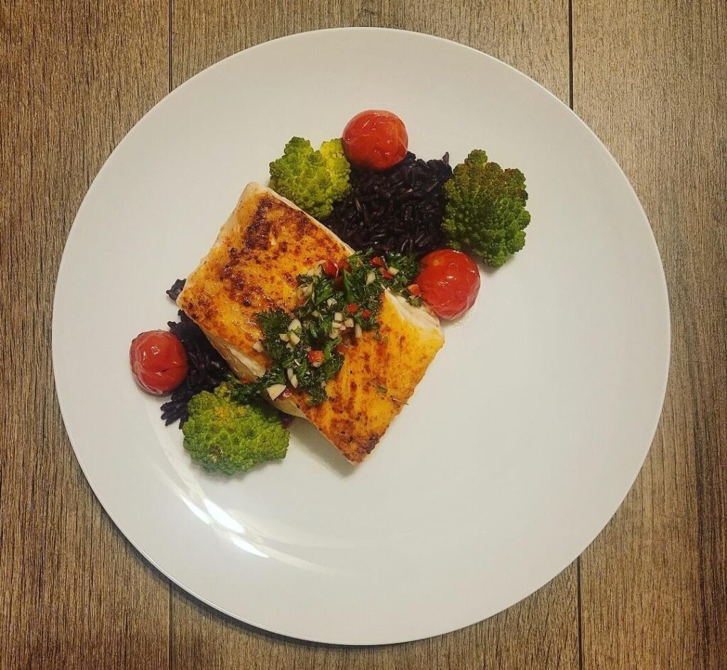 Seared Halibut Fillet with Chimichurri, blistered Ruby Tomatoes and Romanesco on a bed of Forbidden Rice.