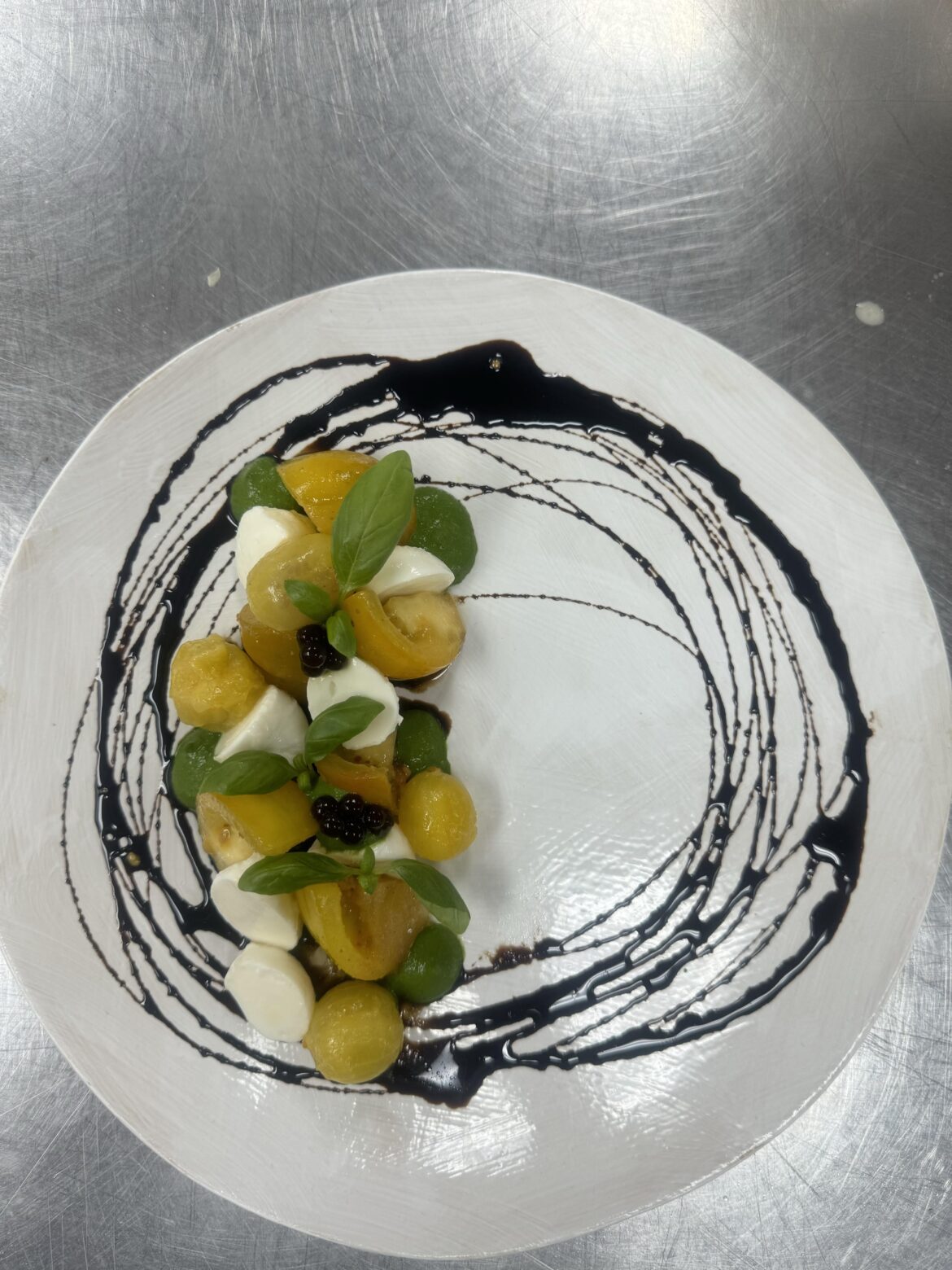 Caprese Salad(heirloom and blistered cherry tomatoes, basil puree,mozzarella, micro basil, balsamic reduction and pearls)