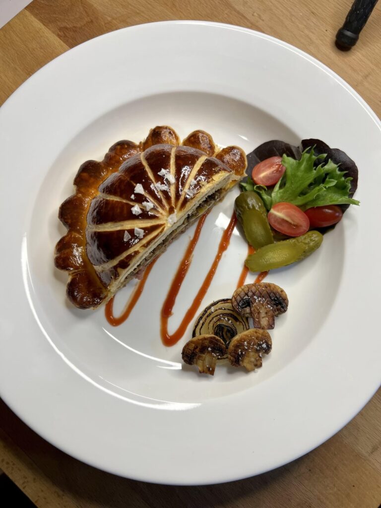 Cheeseburger Wellington : Organic Grass Fed Beef, Sesame Bun, Monterey Jack, Mushroom Duxelles, Caramelized Onion, Cremini, Baby Lettuce, Cornichon, Tomato, Tomato Jus