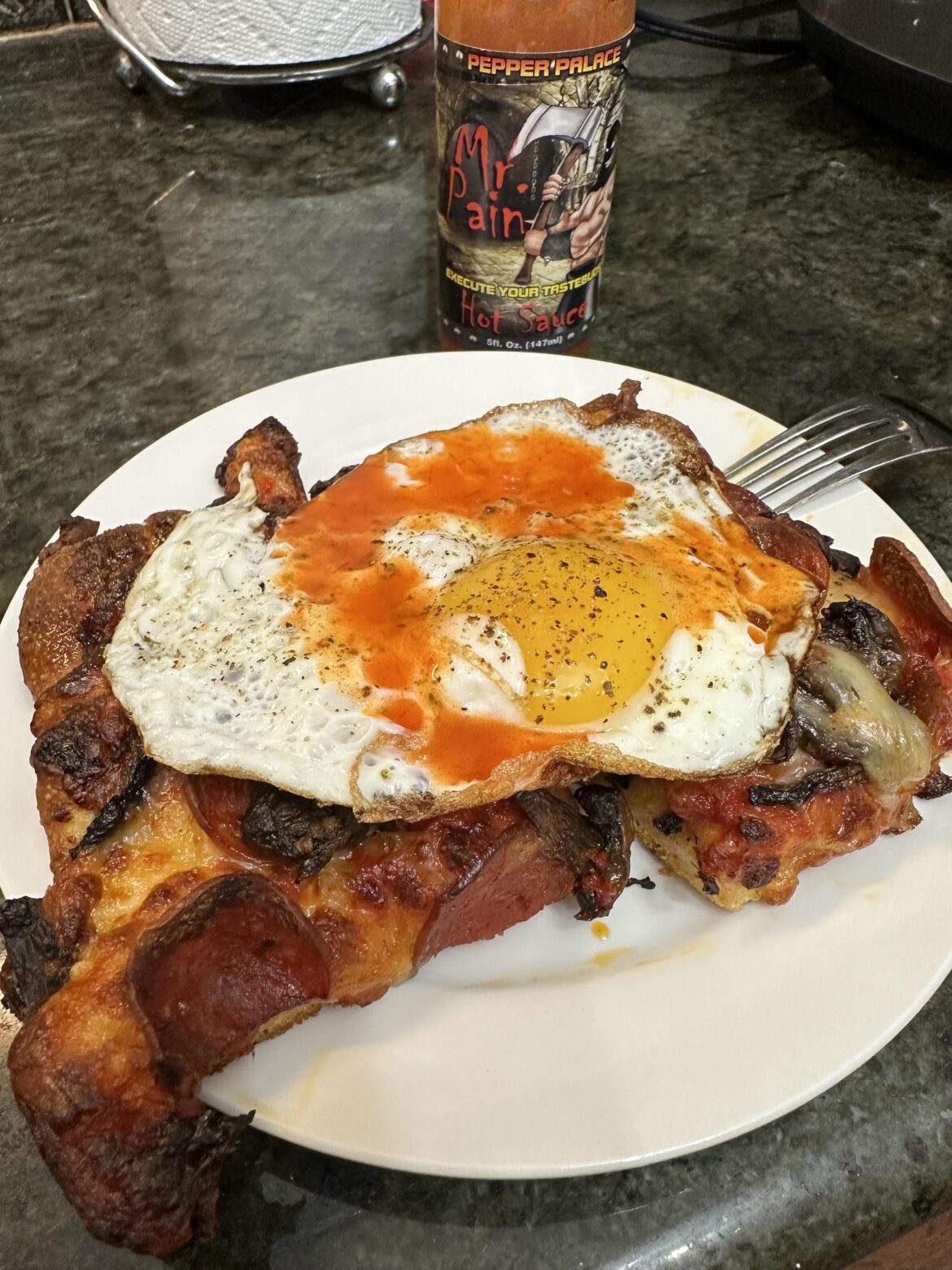 The sunny side up leftover pizza breakfast special with Pepper Palace’s Mr. Pain sauce