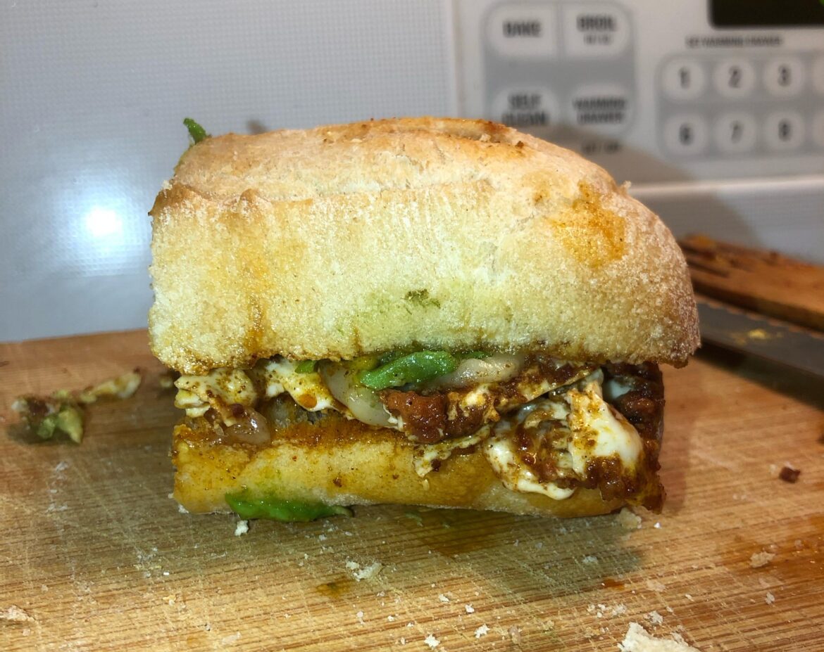 Chorizo and egg breakfast sandwich with cheese, avocado and a hint of mayo on leftover baguette