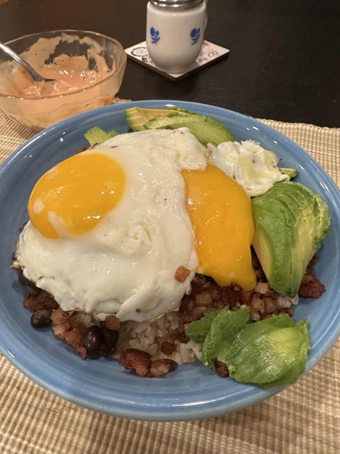 Corned beef hash and black beans on rice, avocado, and of course eggs