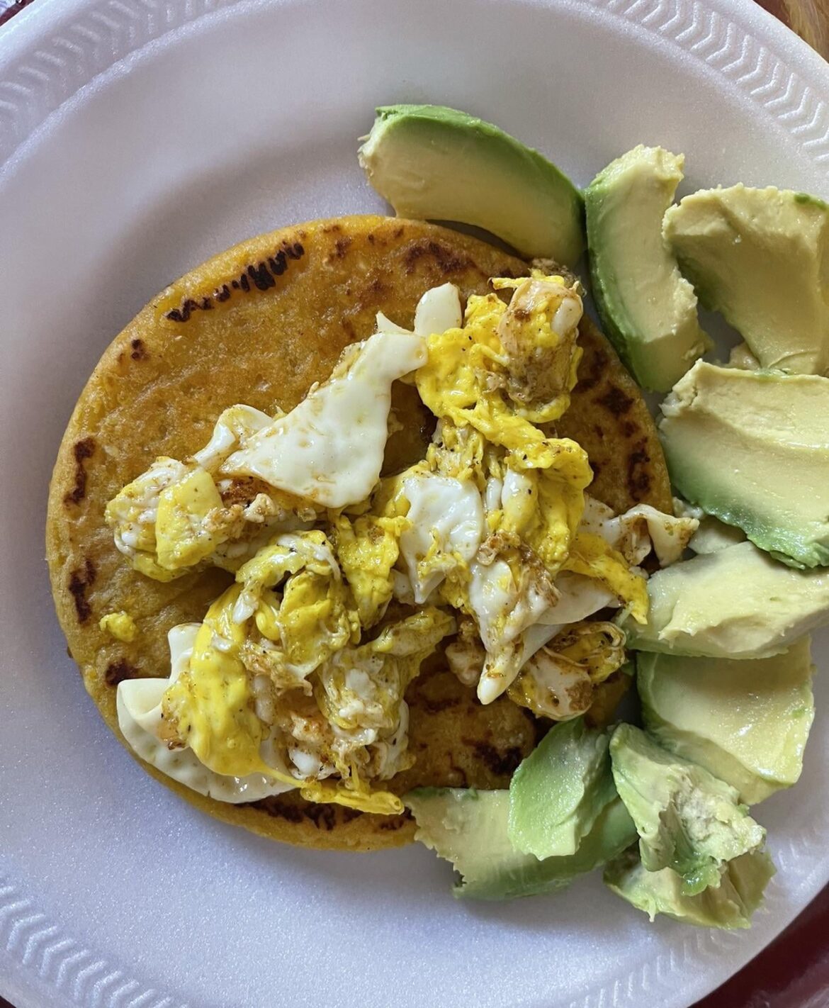 Simple breakfast : Corn arepa with scrambled eggs and avocado.