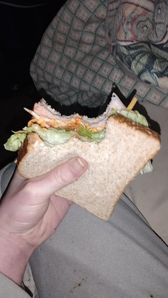 Turkey sandwich with lettuce, shredded tex-mex cheese and franks red hot extra hot sauce.