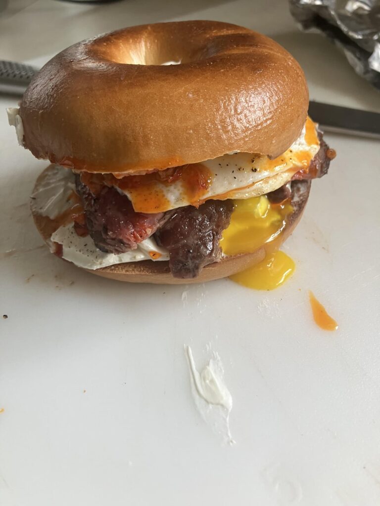 Leftover ribeye, cream cheese, egg, and pepper relish on toasted bagel