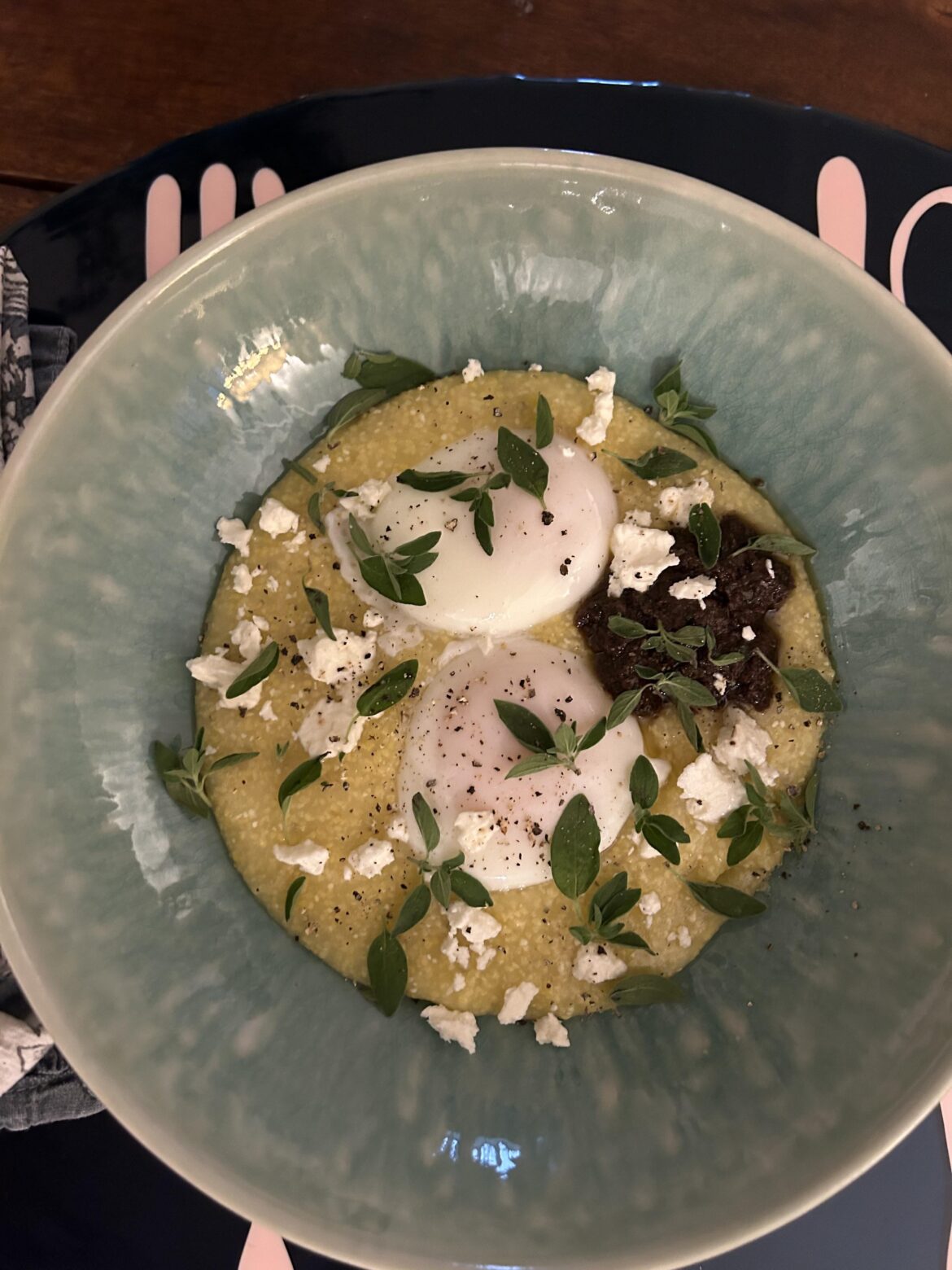 Poached eggs with polenta, tapenade, feta, and oregano