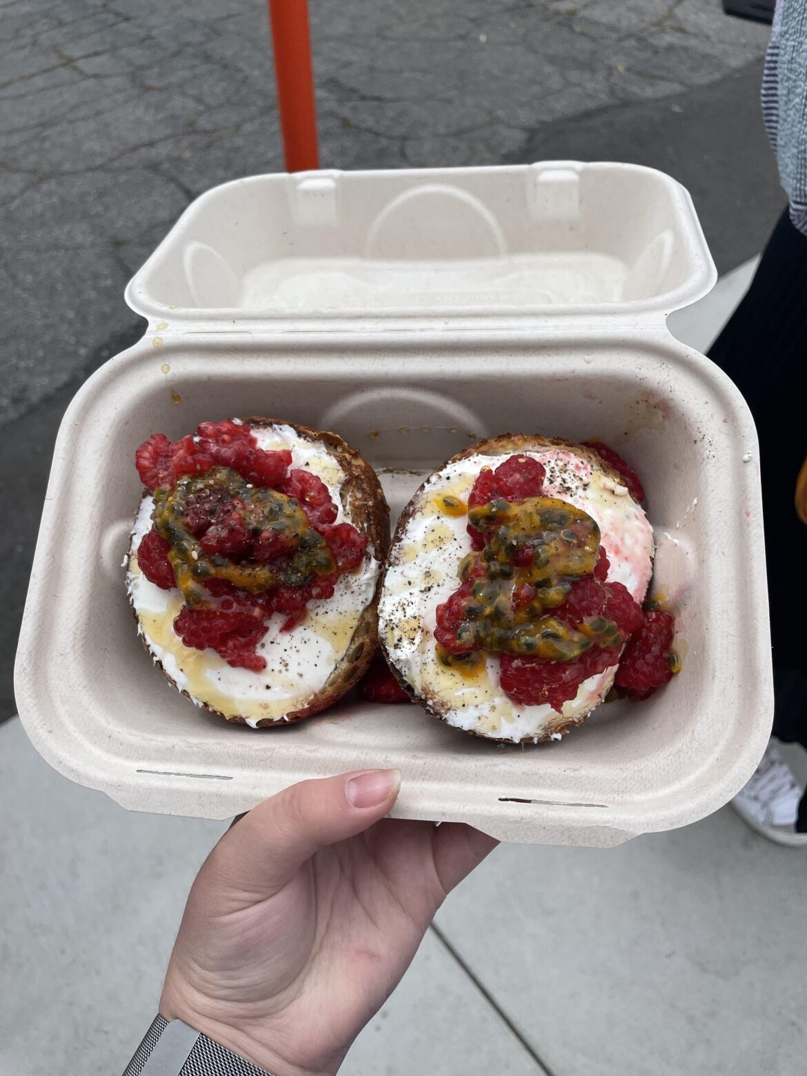 bagel with cream cheese, raspberry, and passion fruit toppings