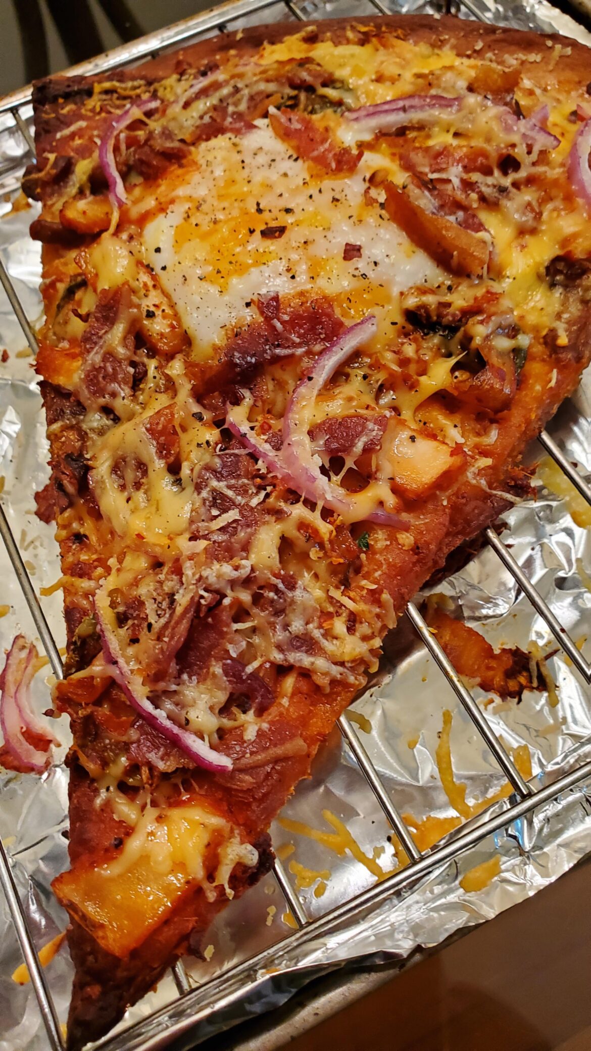 Decided to turn leftover pizza slice into a breakfast with egg, bacon, kimchi and more cheese.