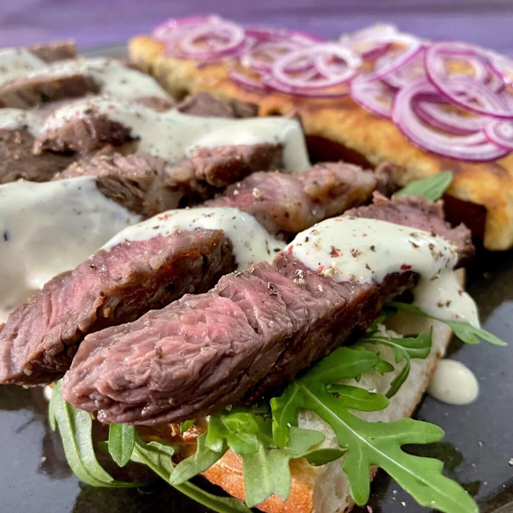 Ribeye steak baguette with horseradish sauce. Added swiss cheese, red onions and arugula.