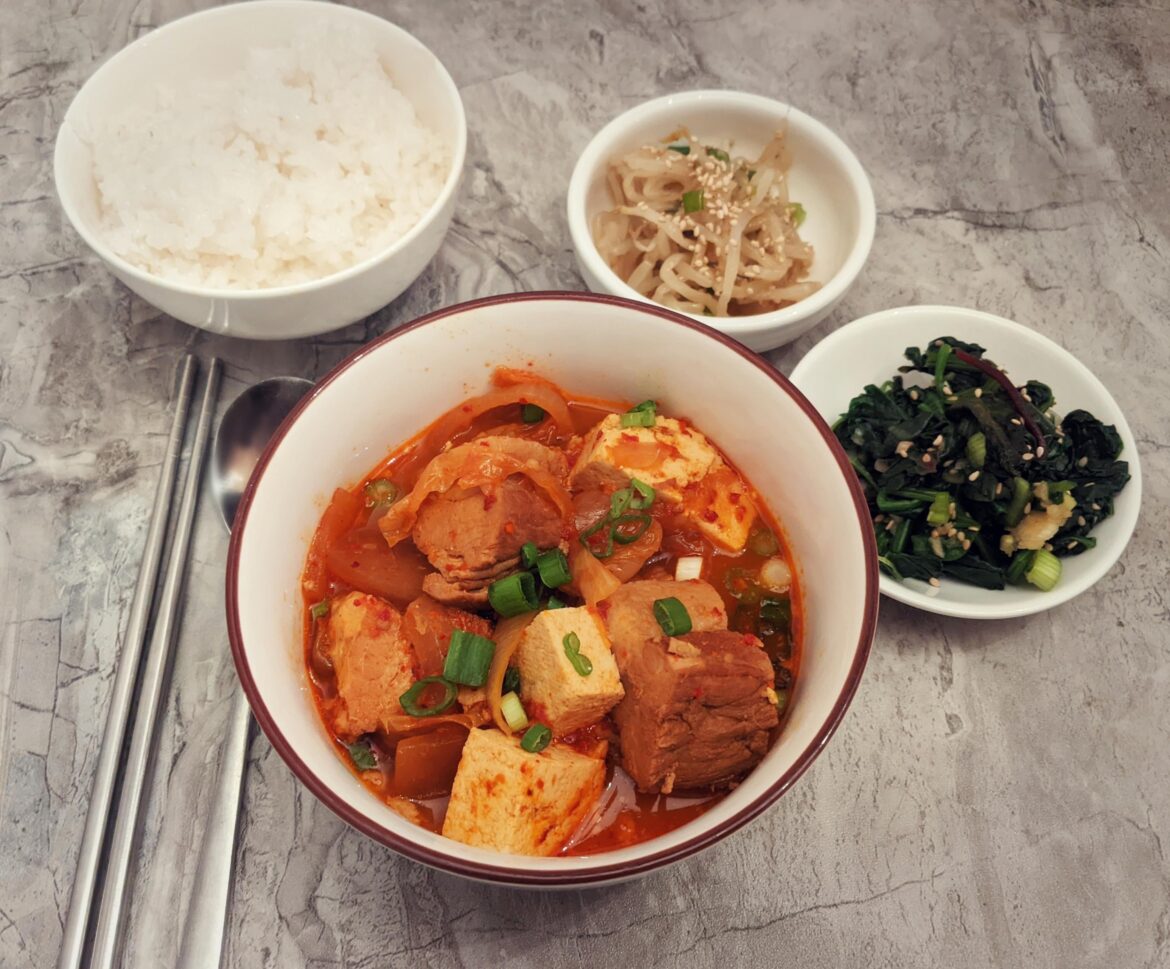 Kimchi jjim with pork belly and tofu, sukjunamul, sigeumchi namul.