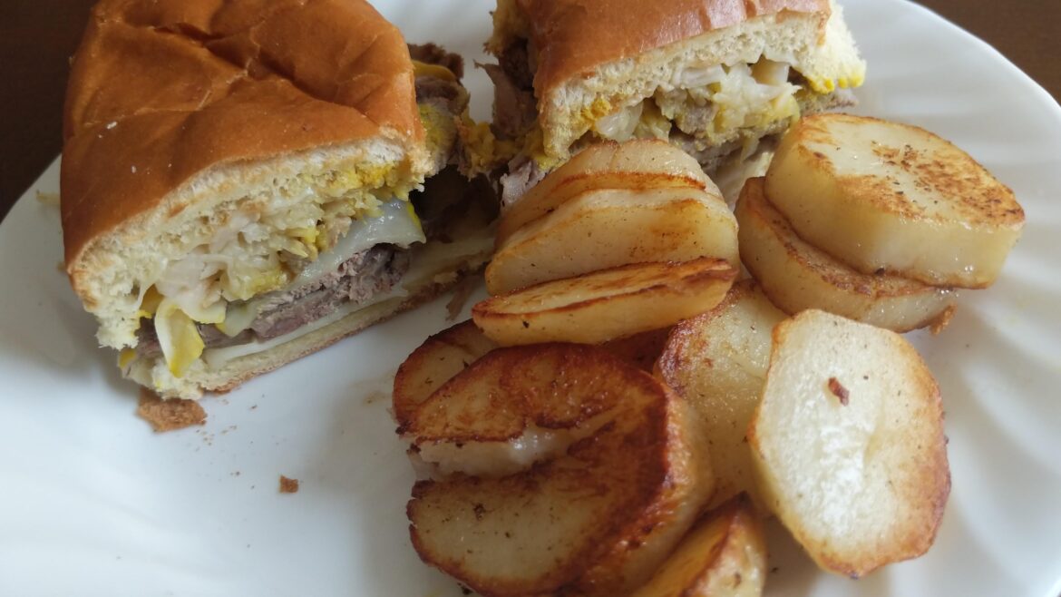 Toasted roast beef & swiss with sauerkraut and mustard. Home fries on the side.